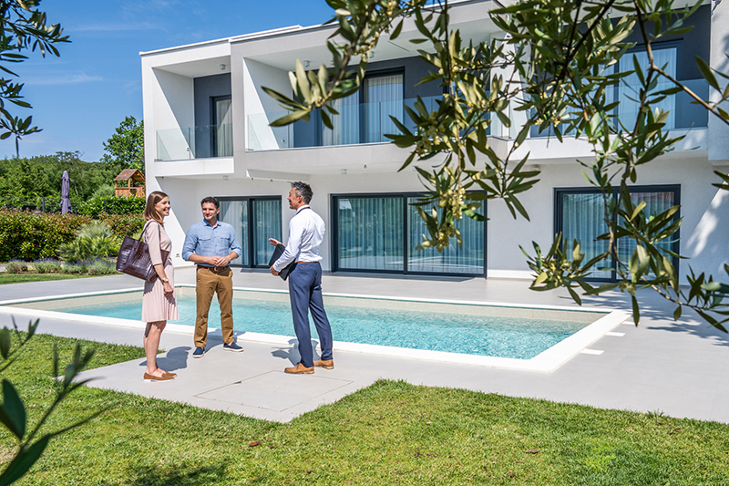 Male real estate agent talking with couple